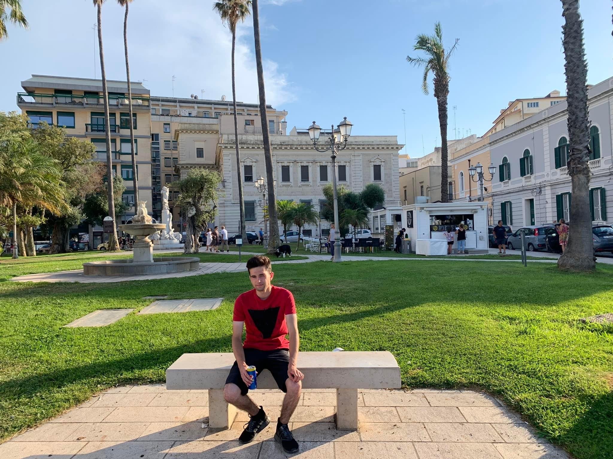 Francesco sitting down with a can of pop in Brindisi, Italy.